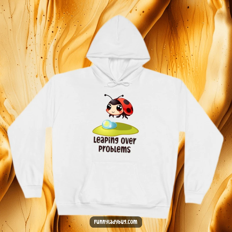 Funny Hoodie: A large-eyed ladybug takes a spectacular leap over a tiny dewdrop, showcasing energetic and playful insect art.
